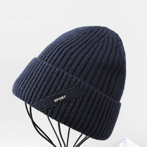 Dettaglio del berretto in maglia blu navy con etichetta sport, trama a coste e pile caldo