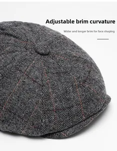Close-up of dark grey wool newsboy cap with red plaid pattern and foldable wide brim