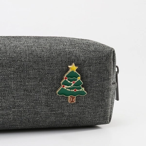 Gray fabric organizer pouch featuring a festive Christmas tree enamel pin decoration