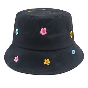 Close-up of colorful flower embroidery details on black cotton bucket hat texture