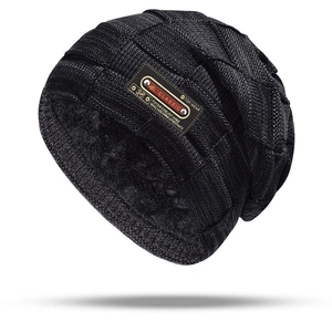 Macro detail of the thick black faux fur lining inside a warm knitted winter beanie