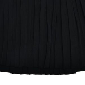 Vue détaillée de l'ourlet de la jupe plissée noire montrant la texture et la coupe