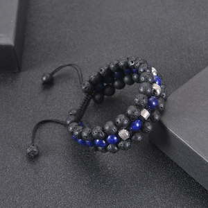 Close-up of triple-layer woven bracelet with lava stone, lapis beads and steel charms