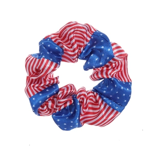 Macro detail of American flag pattern satin scrunchie with silky texture and vibrant colors