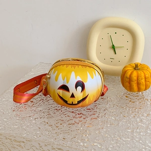 Close-up of smiley face pumpkin crossbody bag on ice texture with autumn props