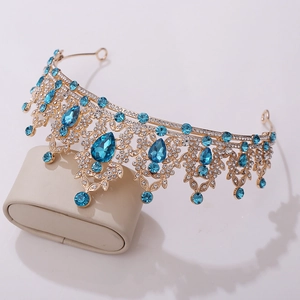 Detailed close-up of golden bridal tiara with blue teardrop stones and rhinestones