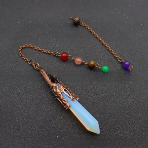 Macro shot of opal hexagonal pillar pendant with antique copper holder and chakra beads