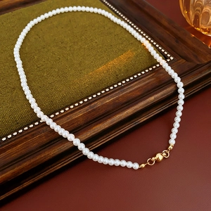 Detail of vintage pearl necklace featuring white pearls and a gold magnetic clasp closure