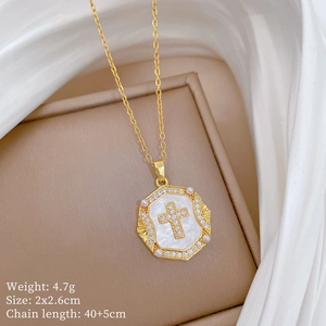 Macro detail of gold cross pendant with pearls and shell inlay on jewelry box