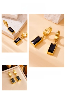 Close-up of gold stainless steel hoop earrings with black rectangular gemstone pendants