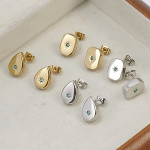 Detailed macro view of waterdrop and rectangular starburst earrings with blue gemstones