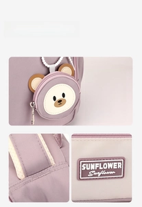 Close-up of lilac backpack with detachable bear pouch, sunflower label and precise stitching