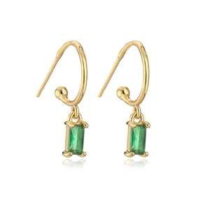 Detail of gold-plated geometric earrings featuring rectangular green zircon pendants