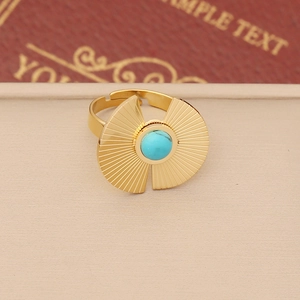 Detailed shot of bohemian gold ring with turquoise stone and radial fan pattern