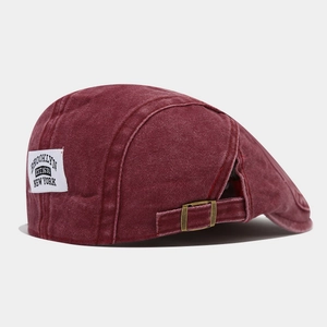 Détail de la boucle en cuivre et du patch Brooklyn sur la casquette en coton bordeaux