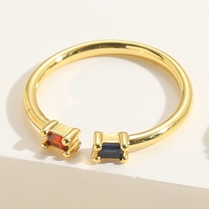 Macro view of gold open ring with rectangle red and blue cubic zirconia stones