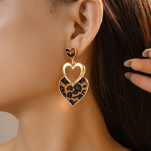 Detail of tiered leopard print heart earrings on model for a trendy autumn look