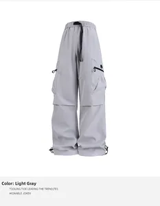Detalle de pantalones cargo gris claro con hebilla táctica y grandes bolsillos de carga