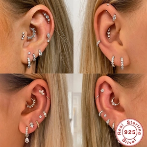 Macro shot of S925 sterling silver earring set with zircon stars and studs on ear