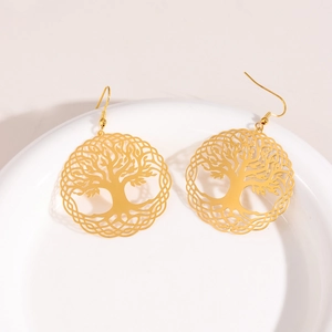 Golden Tree of Life drop earrings in stainless steel on white ceramic display plate