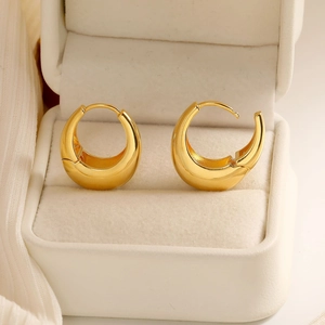 Elegant gold croissant dome earrings with polished finish on a velvet jewelry display