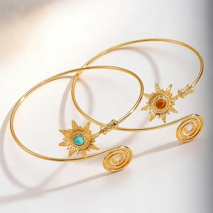 Detailed shot of retro gold arm cuffs with sunburst turquoise and red stone accents
