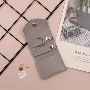 Macro shot of gray suede jewelry pouch showing ring and earring storage compartments