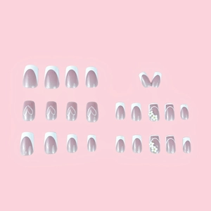 Short square press-on nails featuring white French tips, heart patterns and 3D floral accents