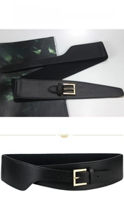 Detail of black elastic corset belt featuring a polished gold square buckle and faux leather