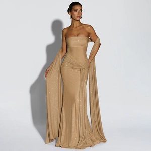Detail view of the shimmering gold evening dress with long elegant flowing drapes