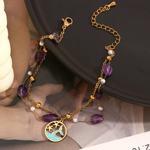 Detail of 18K gold double-layer anklet with purple crystals, pearls and blue fish tail pendant