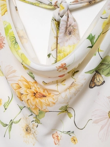 Close-up of floral cowl neckline with tie-knot detail on a summer chiffon dress