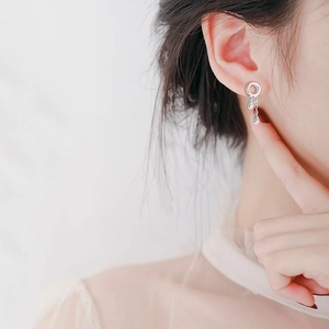 Silver long tassel earrings with sparkling circle and drop charms on a female model