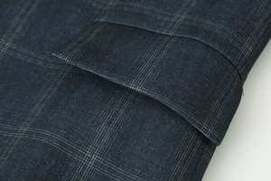 Détail de la veste à carreaux bleu marine avec poche à rabat et coutures précises