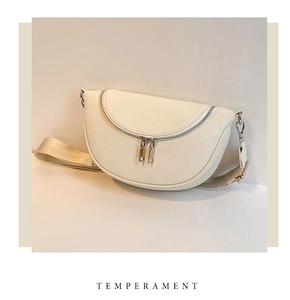 Detailed view of the creamy white pebbled leather texture and double zippers on the half-moon bag