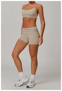 Vue détaillée du short de yoga beige à taille haute avec fronces latérales et ceinture large
