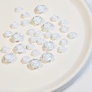 Detailed view of pearl white resin camellia nail charms in mixed 5.8mm and 7.5mm sizes
