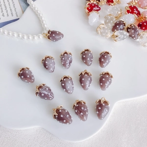 Detail of colorful resin strawberry pendants with pearls and metal rings for DIY jewelry
