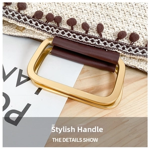 Detail of straw woven tote bag featuring gold metal rings and decorative plush ball charm