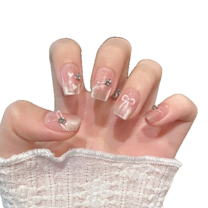 Pink gradient cat eye press-on nails with 3D bows and rhinestones on white background