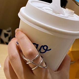 Close-up of silver multi-layer crisscross ring on hand with elegant minimalist design