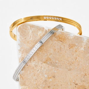 Gold and silver ribbed stainless steel bracelets with central row of inlaid zircon crystals