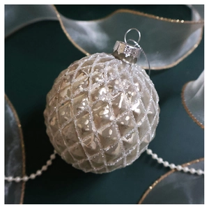 Detailed macro view of a silver glass Christmas bauble with diamond texture and glitter