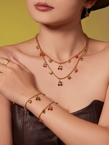 Ensemble détaillé collier, bracelet et boucles d'oreilles cerise et cœur d'or sur mannequin