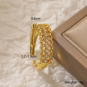Macro side view of a gold-plated geometric ring with sparkling zircon stone accents