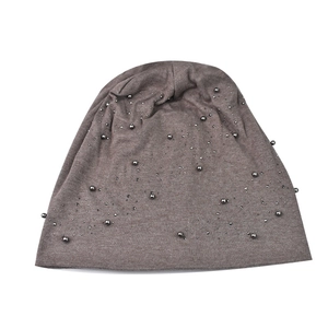 Detail of soft dark brown knit beanie with stylish metallic bead embellishments