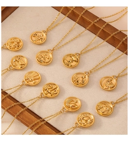 Collection of twelve gold zodiac necklaces displayed on a beige velvet wooden tray