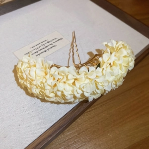 Detail of elegant cream fabric flower hair pin with golden metal U-shaped base