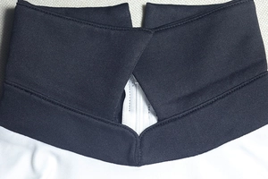 Detail of the high collar with V-shaped neckline and contrast stitching on a fitted dress
