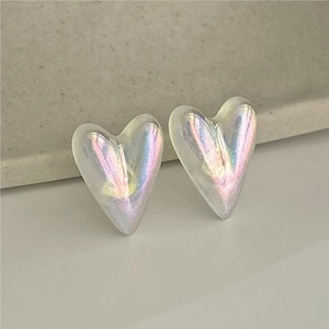 Detailed close-up of iridescent heart earrings with frosted translucent finish on tray
